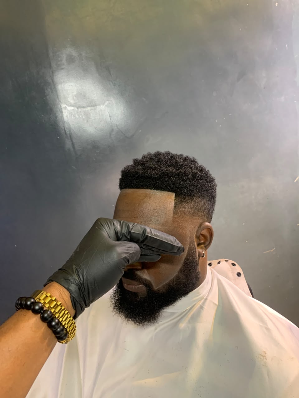 Barber detailing the hairline of a textured haircut
